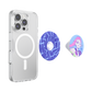 A clear protective phone case shown on a smartphone, with two detachable circular accessories displayed beside it: one blue patterned ring and one round pop socket featuring a pink-haired illustrated character.