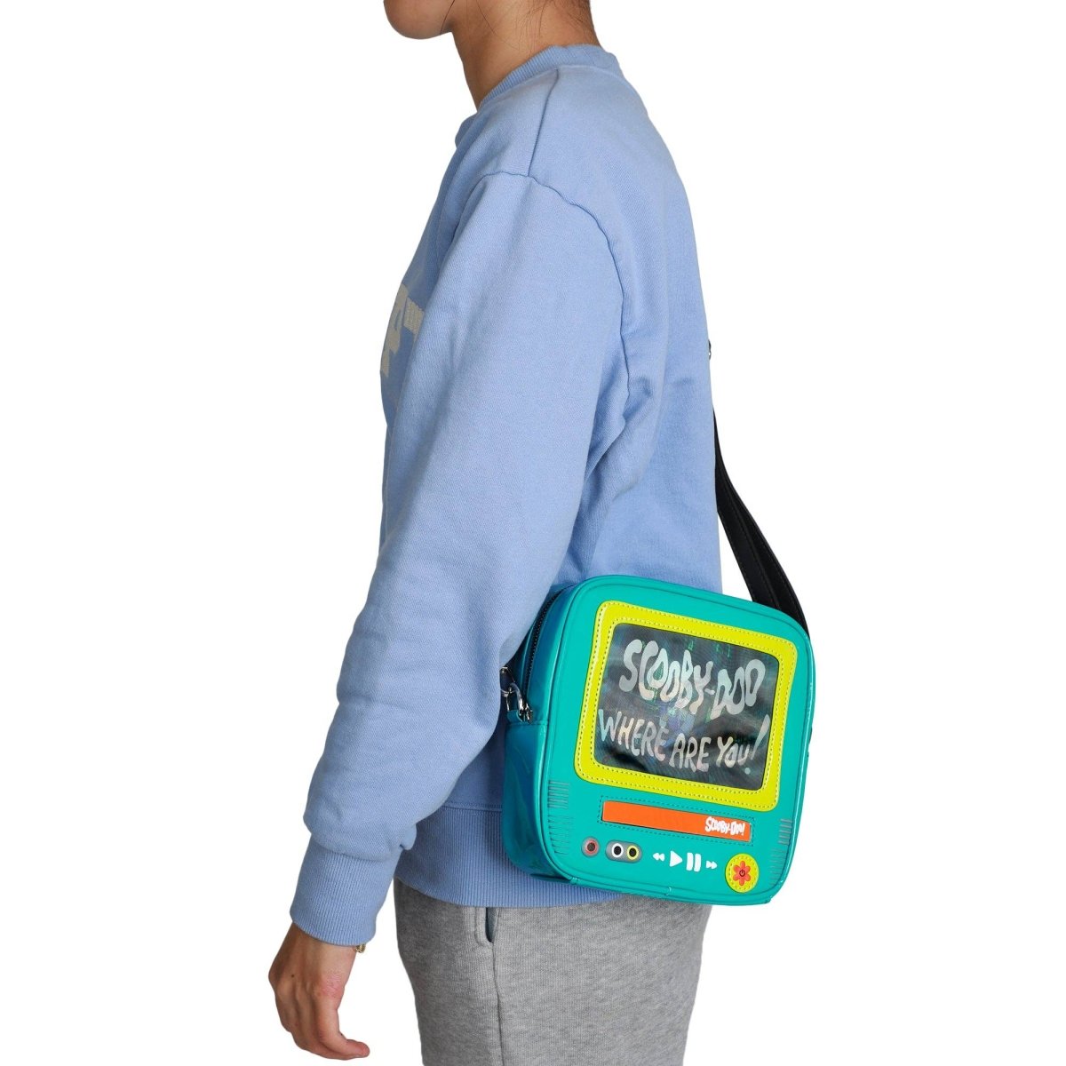 Person wearing a blue sweatshirt with a turquoise bag featuring 'Scooby-Doo' text.