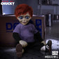 Toy figure of a character with red hair and purple shirt sitting on the floor next to a cardboard box.