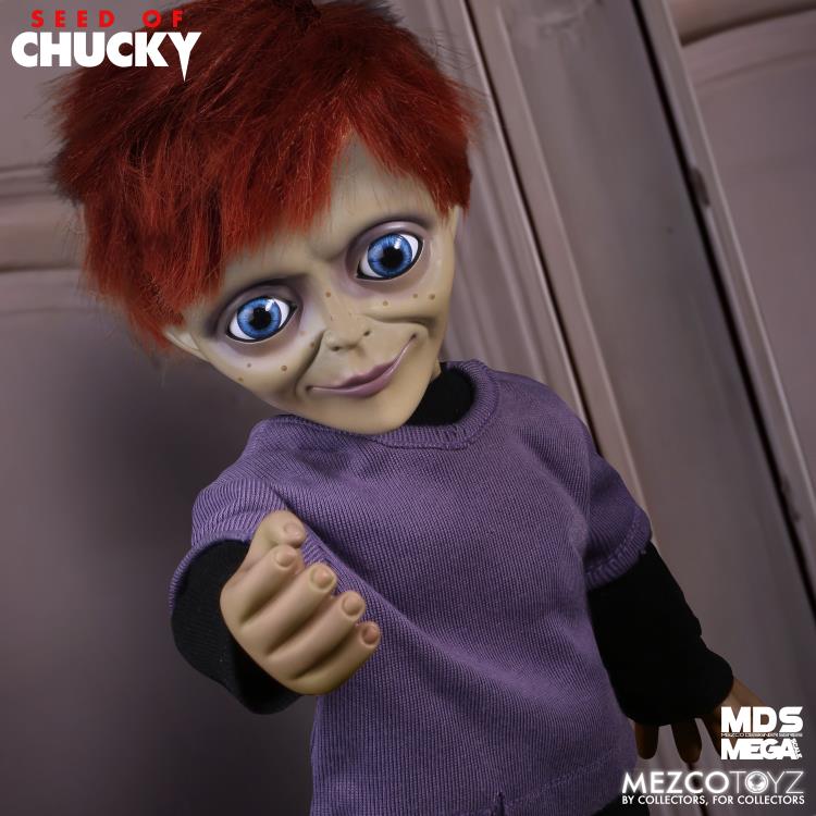 Toy figure of a character with red hair and purple sweater, brand 'Seed of Chucky' visible