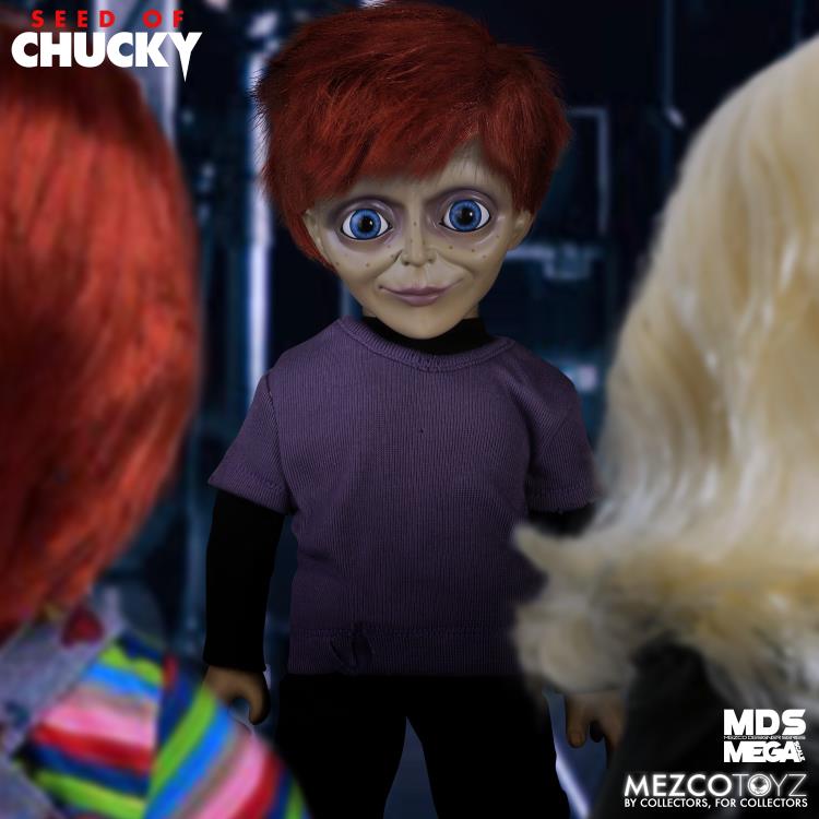 Toy figure with red hair and purple shirt in a dark setting, surrounded by other figures.