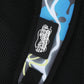 Close-up of a black label with white text on a colorful bag strap.