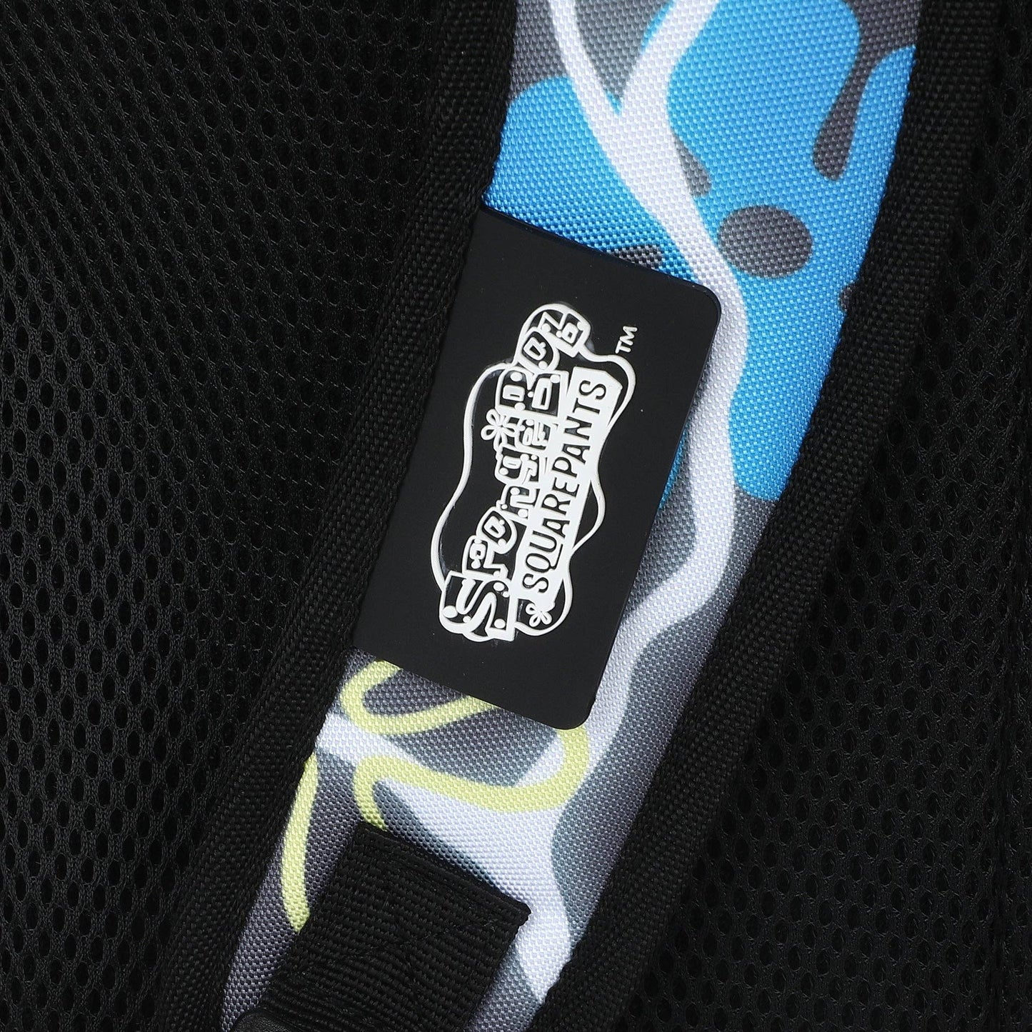 Close-up of a black label with white text on a colorful bag strap.