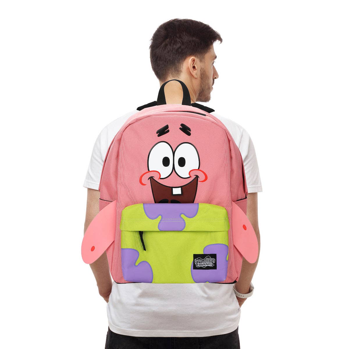 Person wearing a pink and green backpack with a cartoon character design on a white background