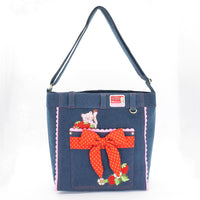 Side angle of Strawberry Shortcake denim tote with sturdy handles and stitched trim