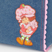 Flat lay of Whatever Makes You Happy Strawberry Shortcake denim tote against a white background