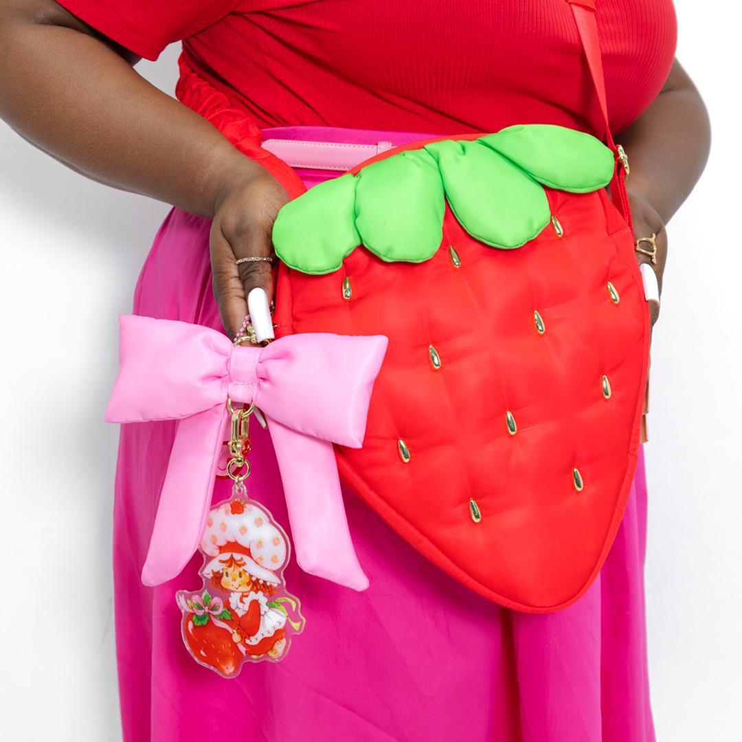 Front view of Strawberry Shortcake crossbody bag shaped like a plump berry with golden seed rivets