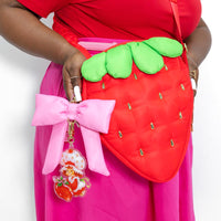 Front view of Strawberry Shortcake crossbody bag shaped like a plump berry with golden seed rivets