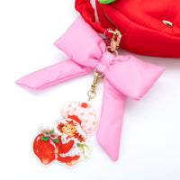 Close-up of Strawberry Shortcake bag showing oversized acrylic character charm and layered logo charm