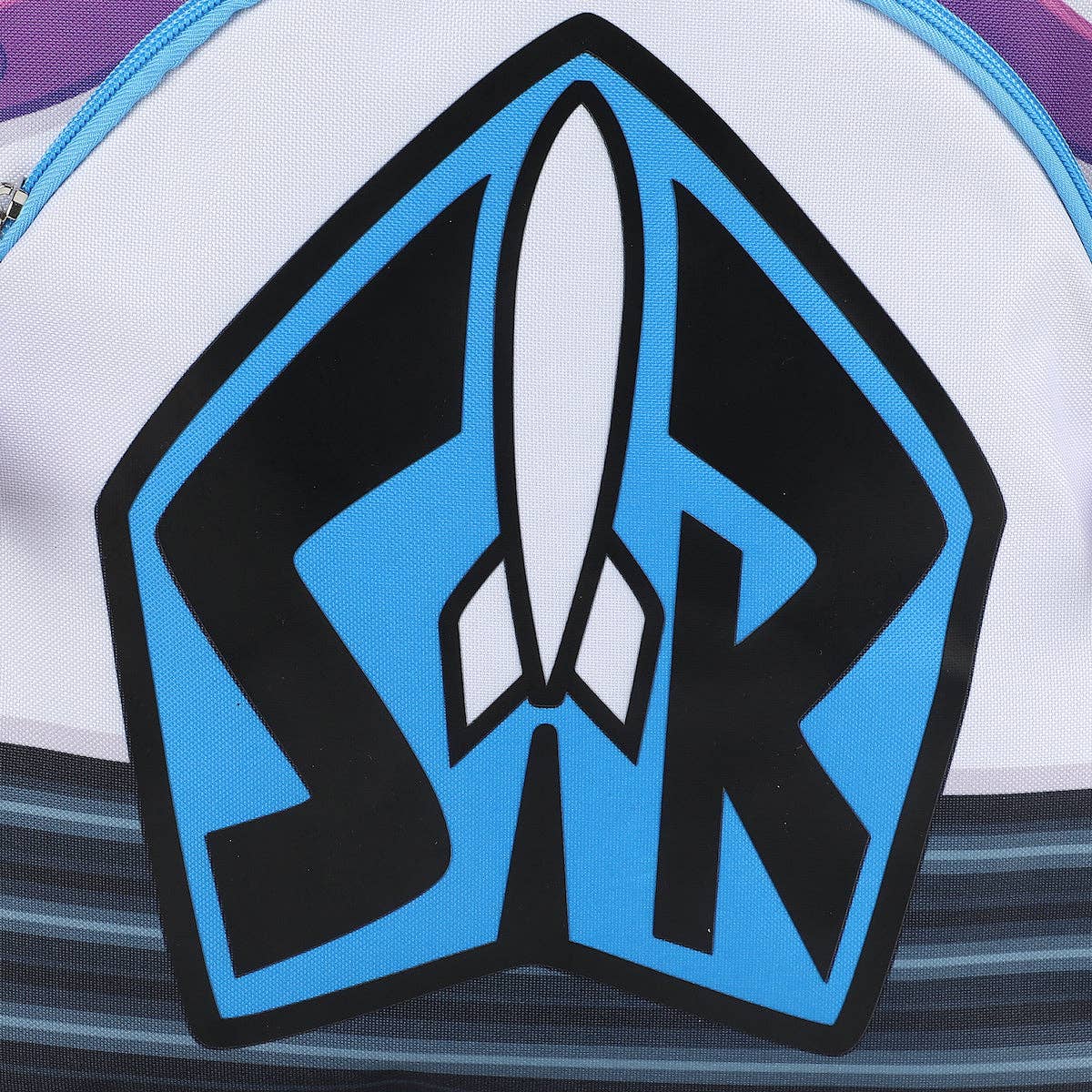 Close-up of a white backpack featuring a large black and blue graphic with a white rocket ship in the center and the letters 'SR' inside a shield-like shape.