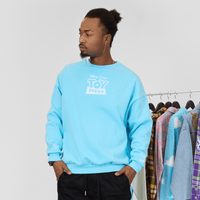 Person wearing a light blue 'Toy Story' sweatshirt in front of a clothing rack.
