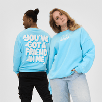 Two people wearing light blue sweatshirts with text on a white background