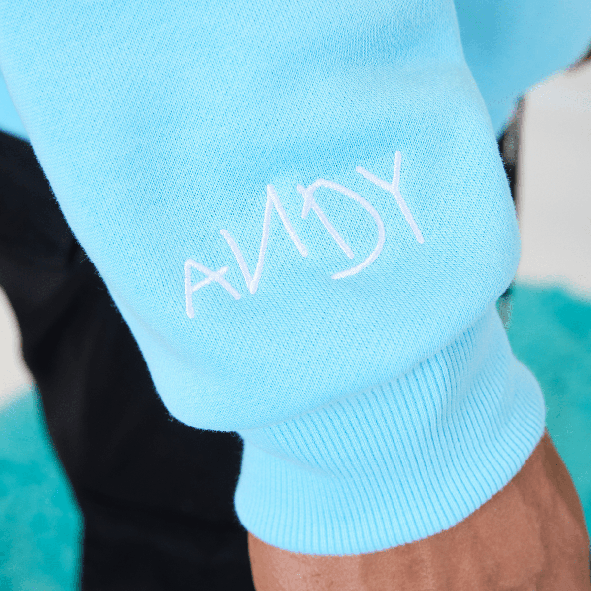 Light blue sleeve with 'ANDY' branding on a blurred background