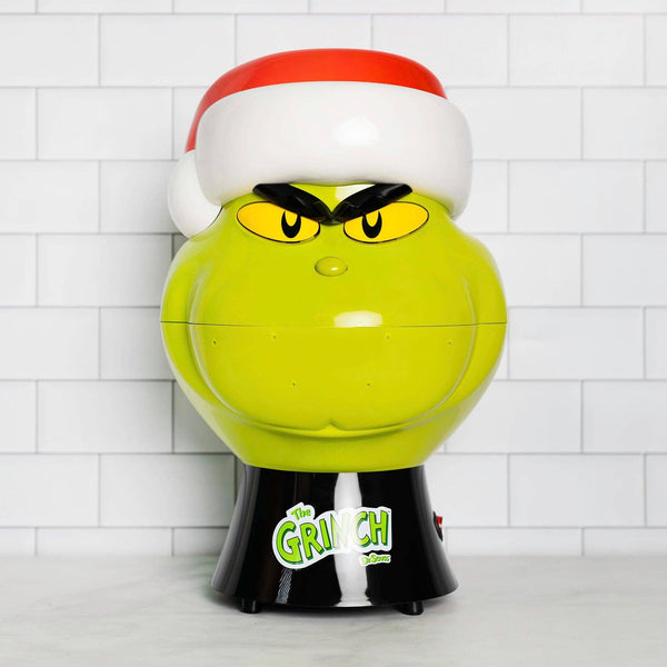Grinch-themed gumball machine with a white tiled background