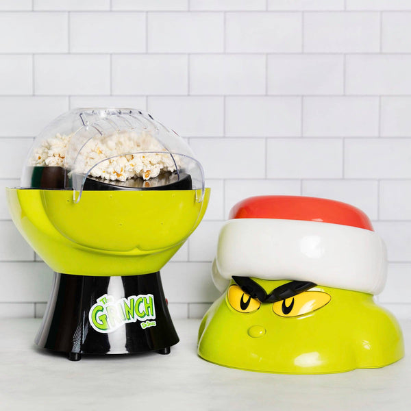 Popcorn maker with 'Grinch' design on a white tiled background