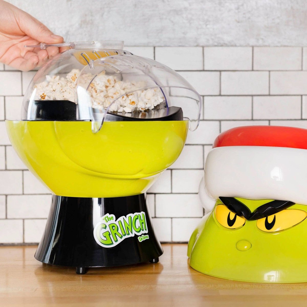 Popcorn maker with 'The Grinch' design on a kitchen counter.