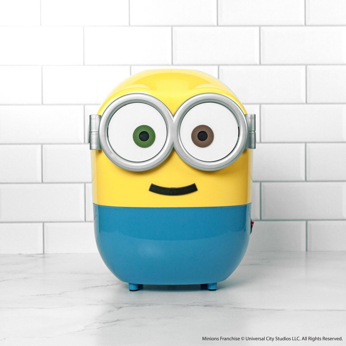 Yellow and blue character with large eyes on a white tiled background