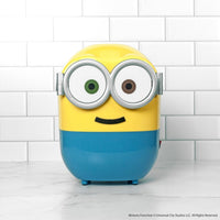 Yellow and blue character with large eyes on a white tiled background