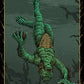 Tarot card featuring a green figure hanging by its wrists with a dark background.