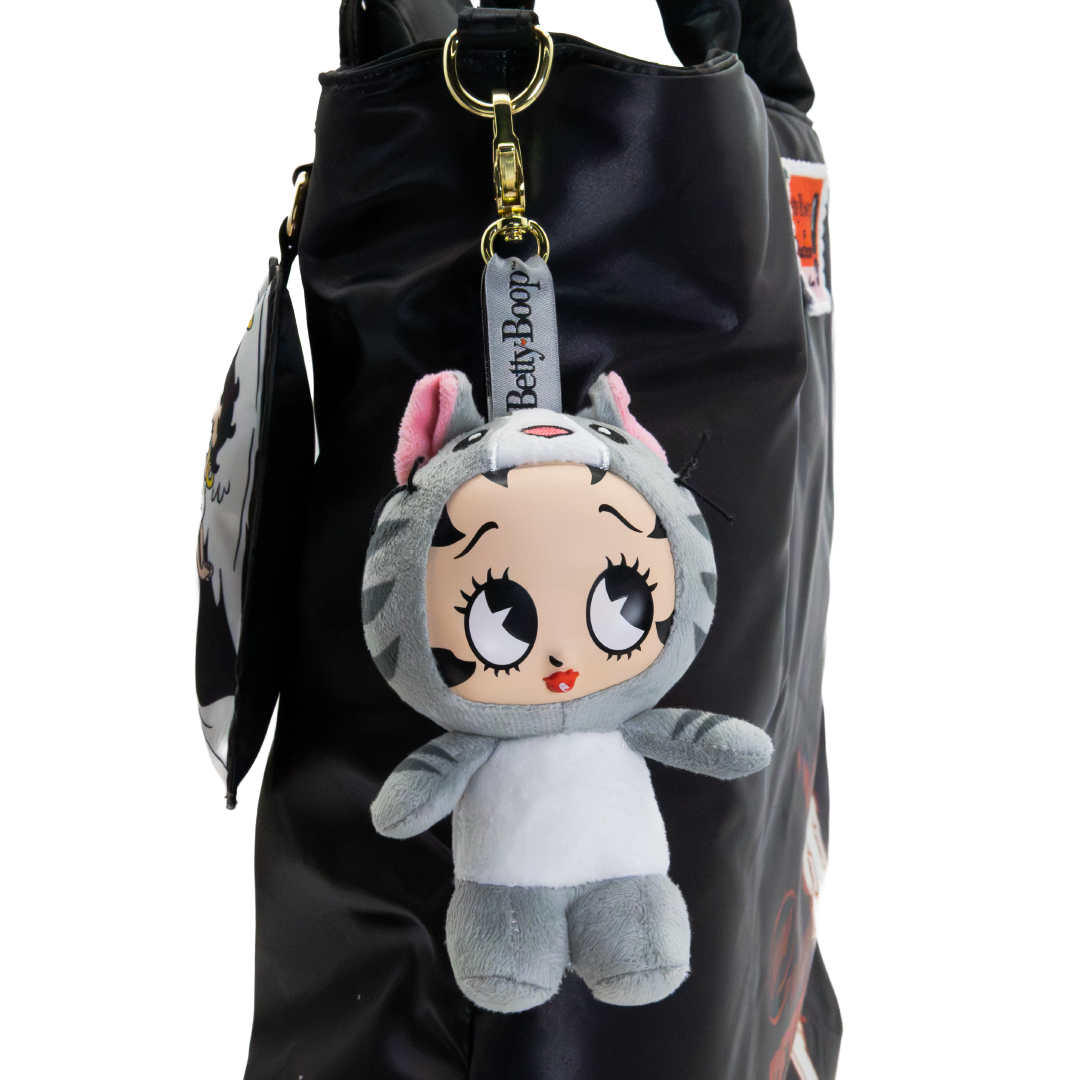 A Betty Boop plush keychain character hanging from a black bag. The plush toy is styled as a cat in a gray and white outfit with pink inner ears, large cartoon-style eyes, and a Betty Boop branded tag attached.