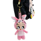 A pink Betty Boop plush bunny keychain charm hanging from a black bag with a cartoon face. The plush features a pink bunny hood with long ears, large expressive eyes, and a pink belly, with a pink tag reading 'Betty Boop' and gold-tone hardware.