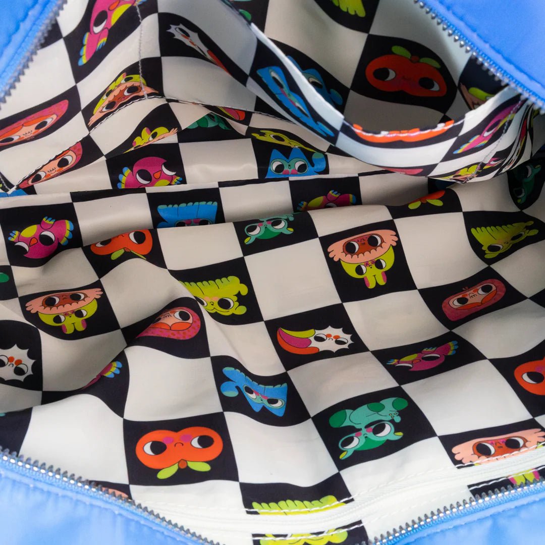 Close-up of a colorful patterned fabric with checkered design and cartoonish faces on a blue background.