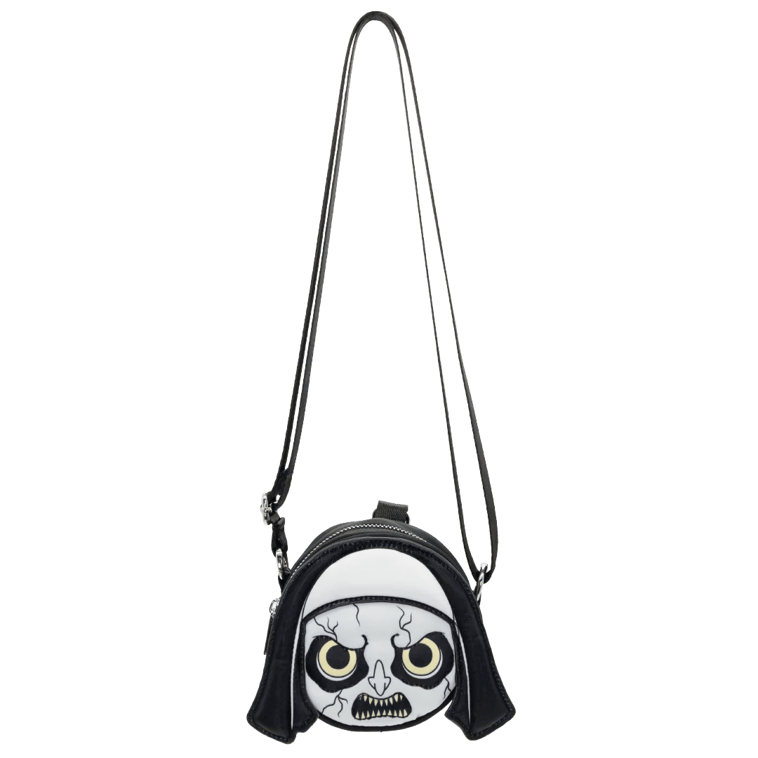 A small black and white crossbody bag featuring a stylized skull face design with yellow eyes on the front, shown against a plain white background.