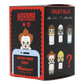 A mystery phone buddy collectible box featuring horror movie characters including Pennywise, The Exorcist, The Addams Family, and The Nun. The packaging is black and red with illustrations of the characters and a placeholder phone graphic.