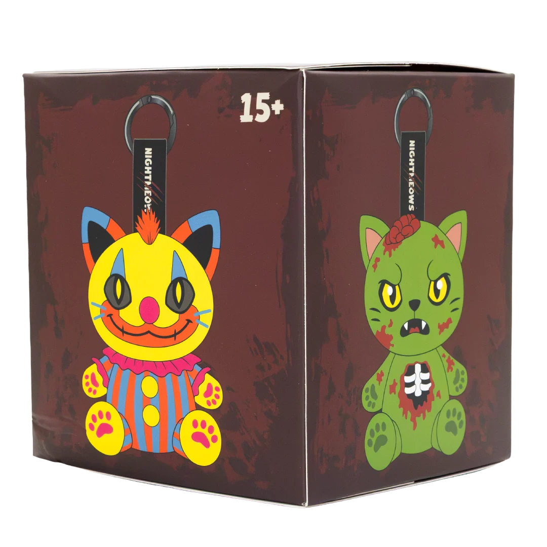 A boxed collectible product shown at a slight angle on a plain white background. The box is dark reddish-brown with distressed texture and features two cartoon cat illustrations on the front and side panels: one yellow clown-like cat with blue, orange, and red details, and one green zombie-like cat with blood marks and a white cross on its chest.