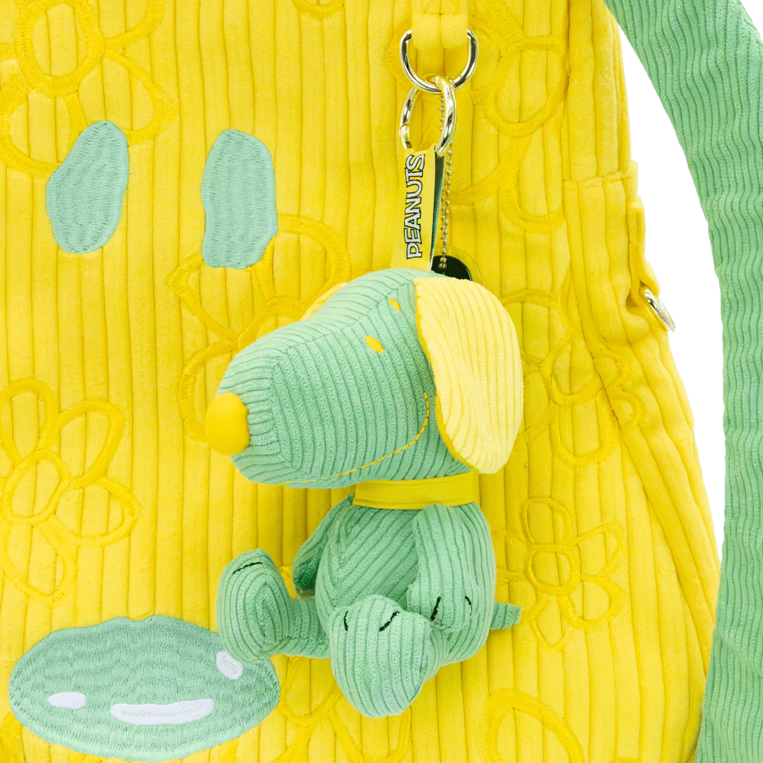 Green dog-shaped keychain attached to a yellow textured bag