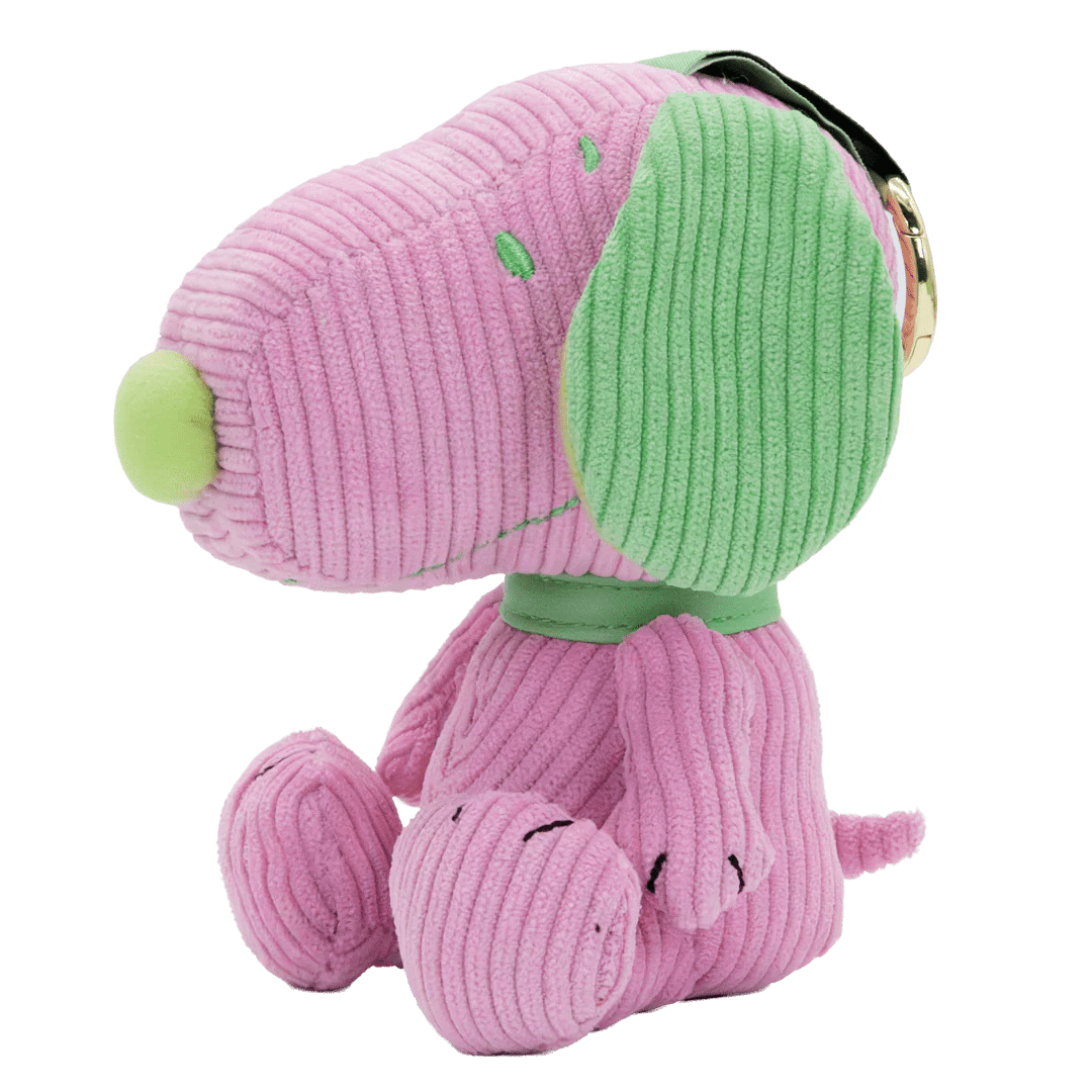 Pink plush dog toy with green accents on a white background