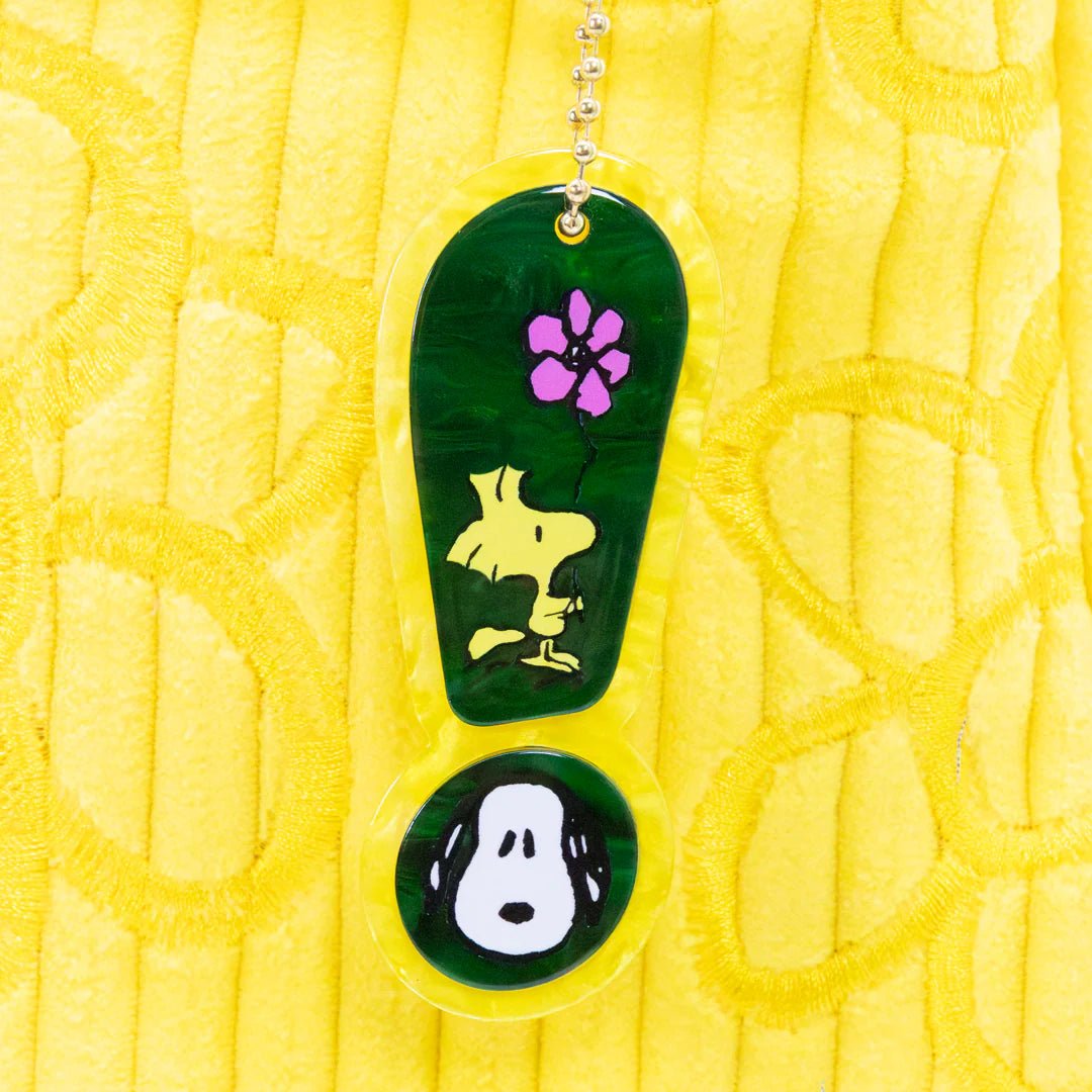 Keychain with green flip-flop design featuring a dog and paw print on a yellow textured background