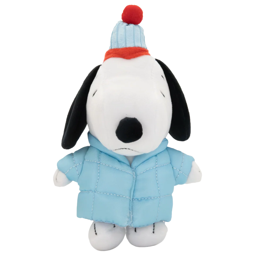 A plush Snoopy doll wearing a light blue quilted puffer jacket, a striped blue and white knit hat with a red pom-pom, and a red knit scarf, set against a plain white background.