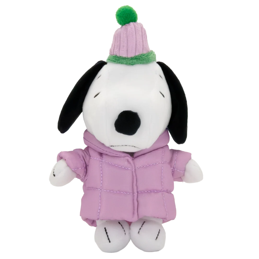 A plush Snoopy doll wearing a light pink puffer jacket and a matching pink knit hat with a green pom-pom, set against a plain white background.