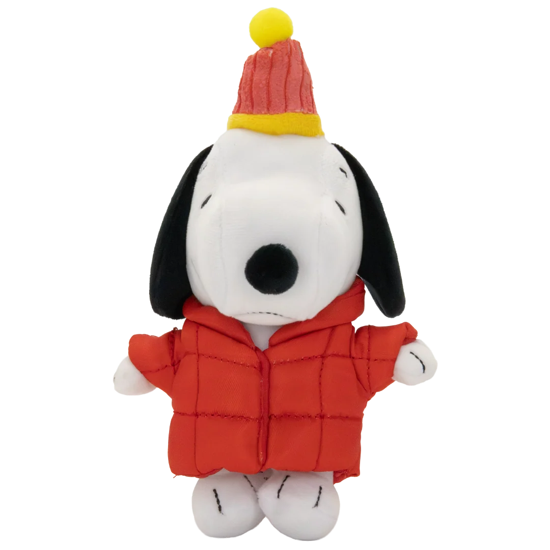 A plush toy of Snoopy wearing a red puffer jacket and a red and yellow striped party hat with a yellow pom-pom, set against a plain white background.