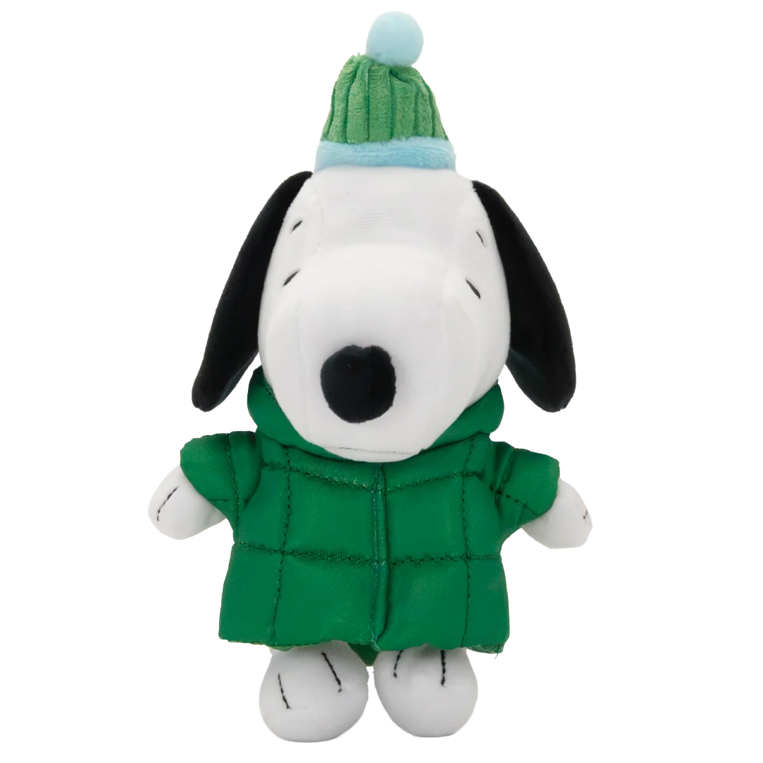 A plush toy of Snoopy wearing a green quilted winter coat and a green and light blue knit hat with a pom-pom, set against a plain white background.