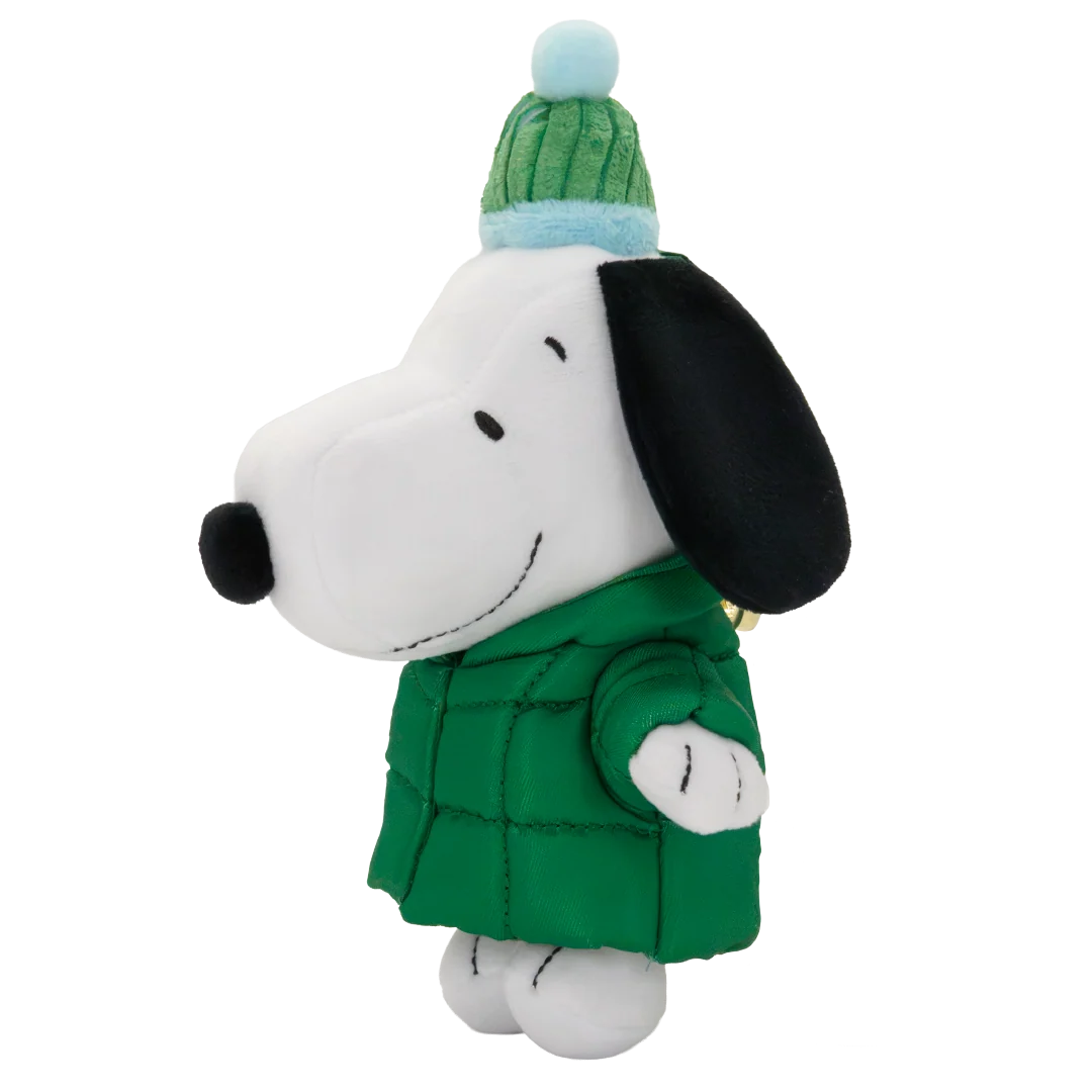 A plush toy of Snoopy wearing a green quilted jacket and a green and light blue knit beanie hat, set against a plain white background.