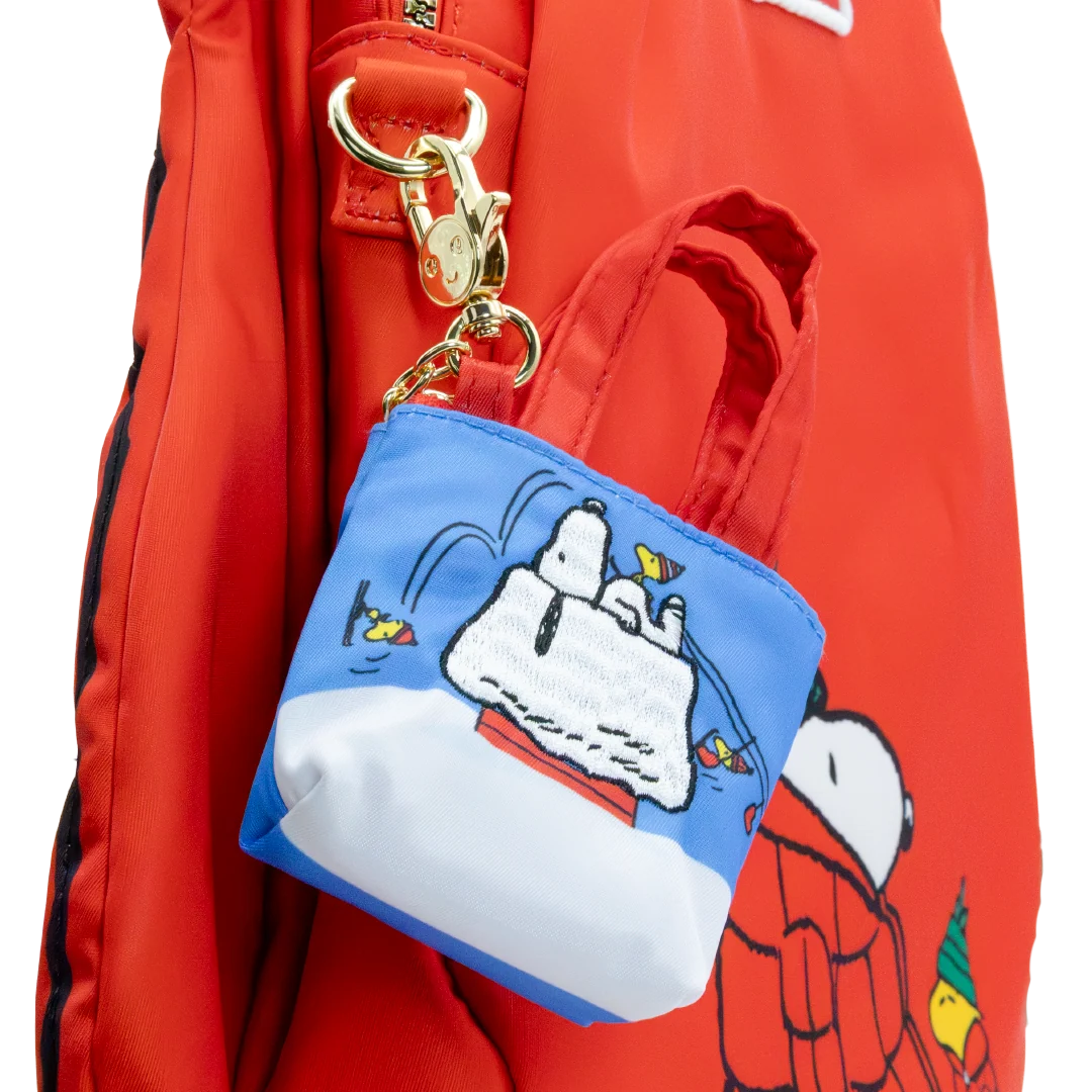 A red nylon backpack with a small attached blue and white Snoopy fishing pouch charm, shown against a white background.