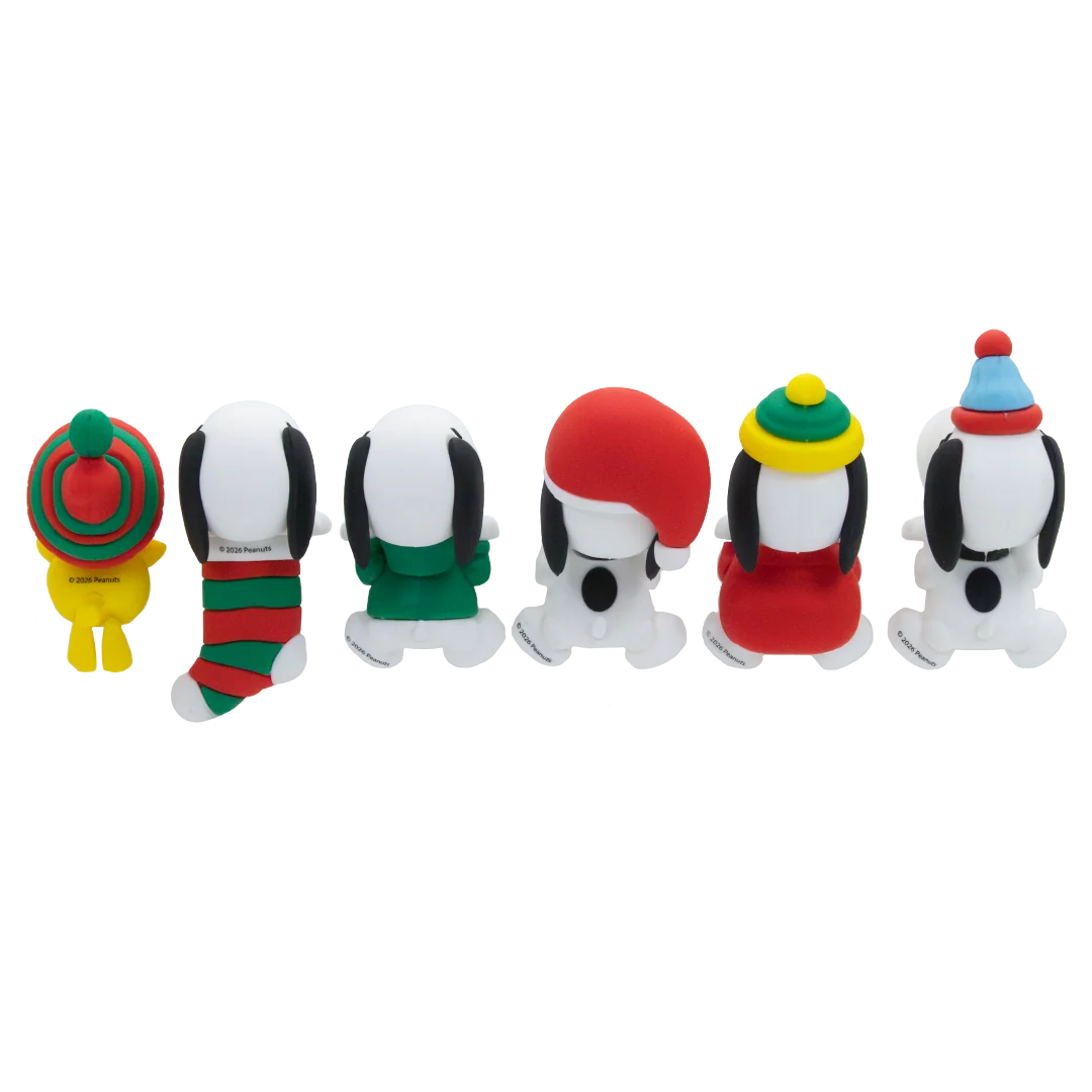 Six small Snoopy character figurines lined up on a plain white background, each wearing a different colorful holiday-themed outfit or hat.