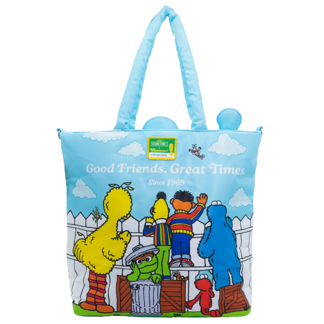 A Sesame Street canvas tote bag featuring the characters Big Bird, Oscar the Grouch, Cookie Monster, and Elmo on a light blue background with 'Good Friends. Great Times Since 1969' printed on the front.