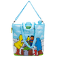 A light blue tote bag featuring a colorful print of Sesame Street characters, including Big Bird, Cookie Monster, and the Blue Monster, with the text 'Good Friends, Great Times Since 1969'. The bag has a light blue shoulder strap and handles, and a Sesame Street logo is visible on the front.