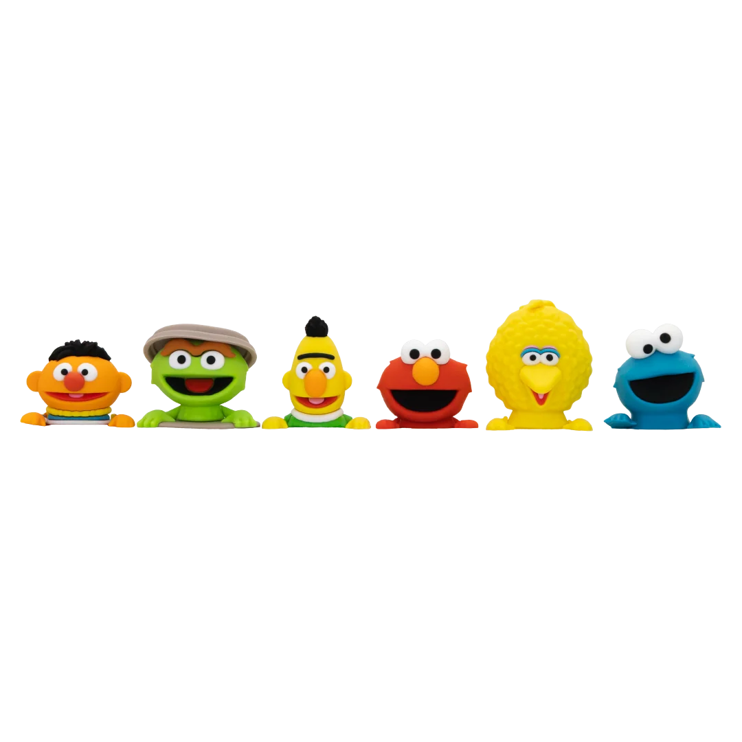 Six Sesame Street character plush toys lined up in a row against a plain white background, including Ernie, Oscar, Bert, Elmo, Big Bird, and Cookie Monster.