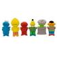 Six Sesame Street character-shaped sponge toys lined up from left to right: Cookie Monster, Big Bird, Elmo, Tony the Tiger, the Drummer, and Abby Cadabby, shown against a plain white background.