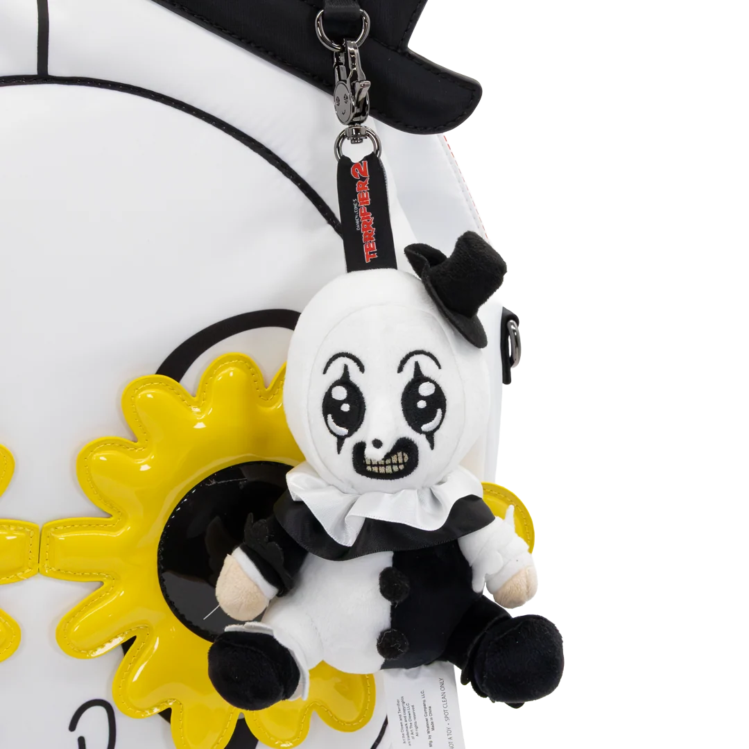 A plush keychain charm of a creepy clown character with a black top hat, white face, and black-and-white outfit, attached to a black strap with red text, shown against a white background.