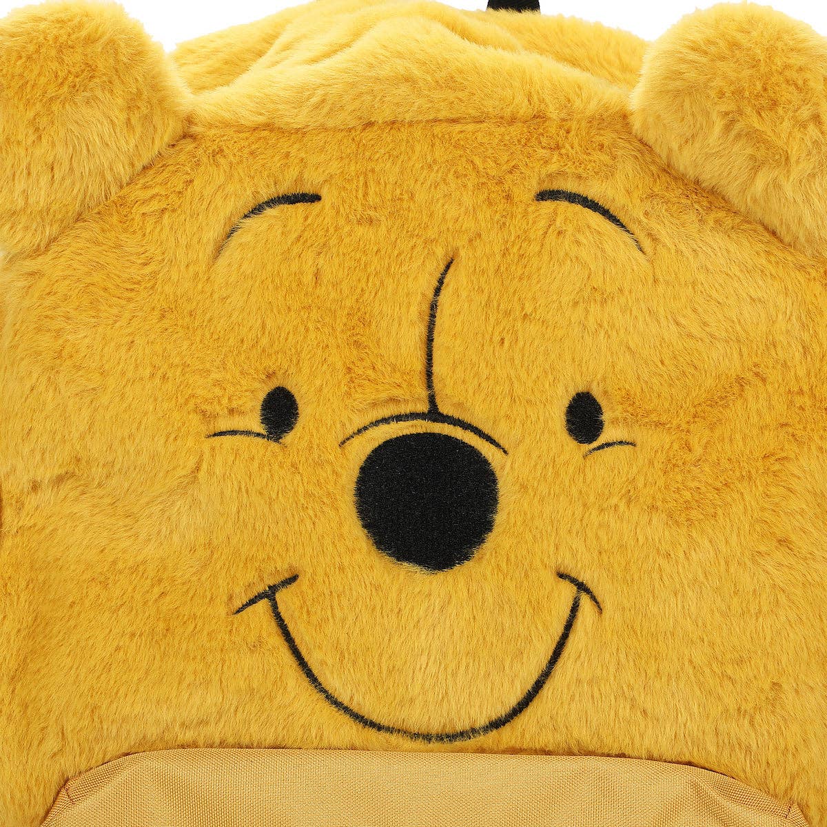 Close-up of a plush bear with a smiling face on a white background