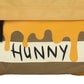 Close-up of a honeycomb with the word 'HUNNY' and honey dripping.