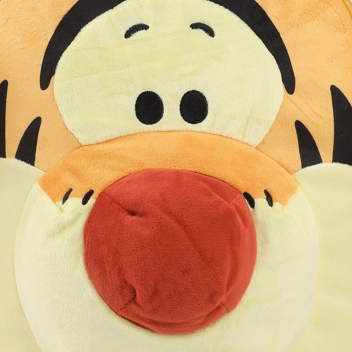 Plush toy of a cartoon character with a red belly on a beige background