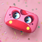 Pink case with cartoon face design on a pink background with confetti