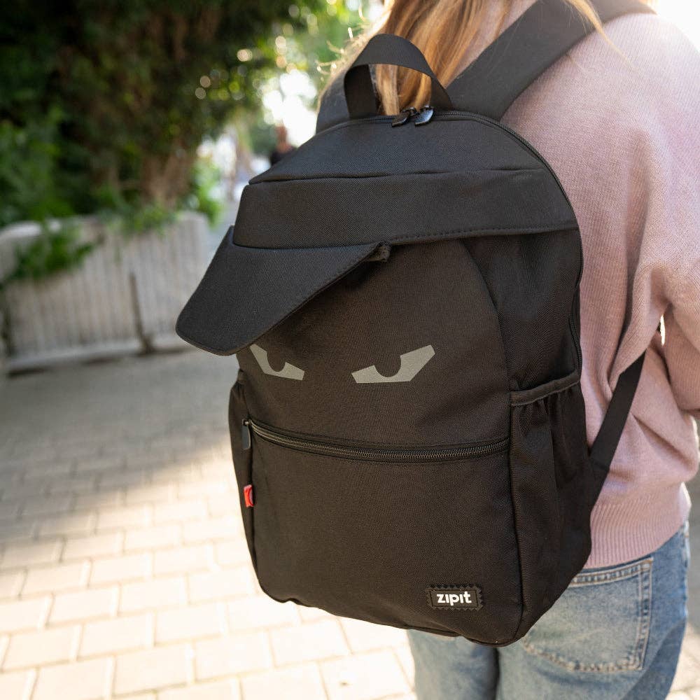 Person wearing a black backpack with a 'zipit' brand logo outdoors.