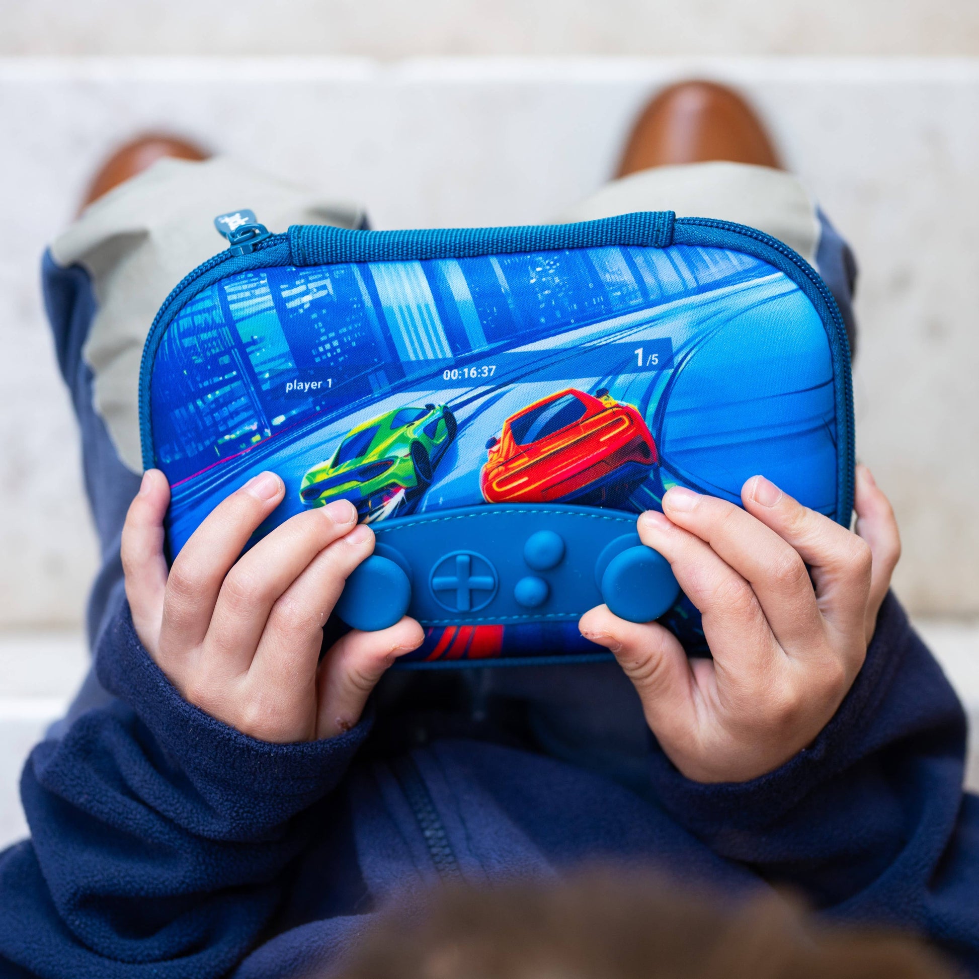 Child holding a blue gaming console case with colorful graphics